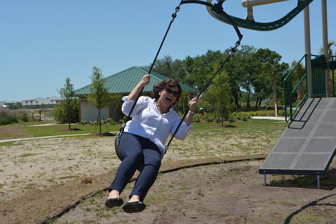 Monaca Onstad, the Schroeder-Manatee Ranch director of community relations, tries out the "Gravity Rail" at Bob Gardner Community Park.
