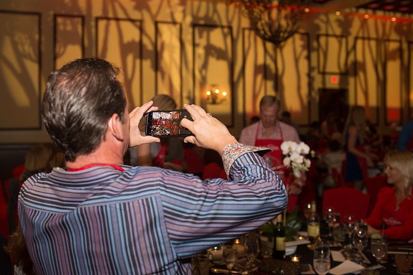 David Neff takes a video of the chefs at his table.