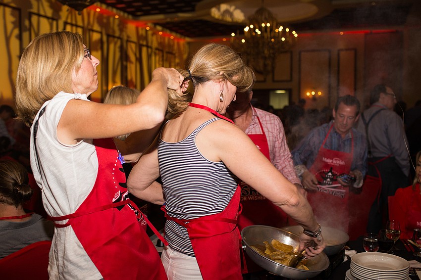 Jan Meissner helps Kelly Taylor tie her hair back.