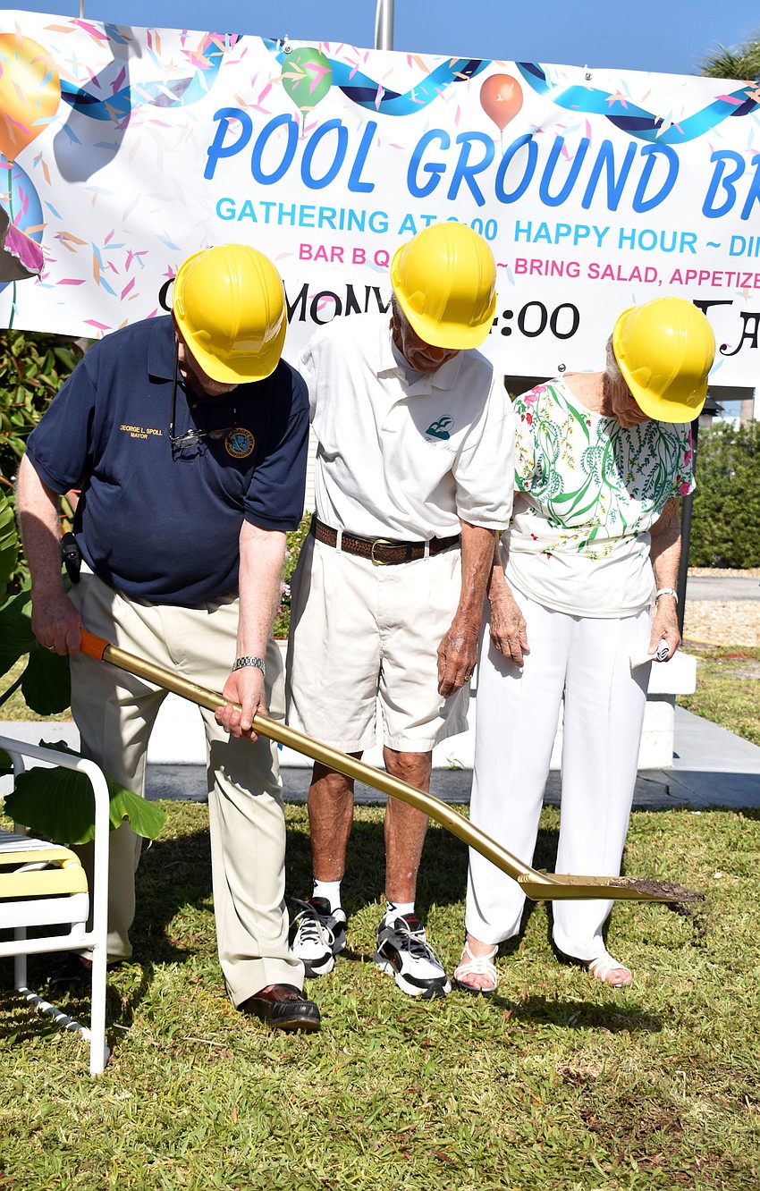 Mayor George Spoll scoops a patch of grass and dirt to mark the official groundbreaking.