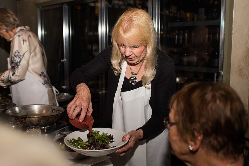 Julie Rohr McHugh puts dressing on the salad.