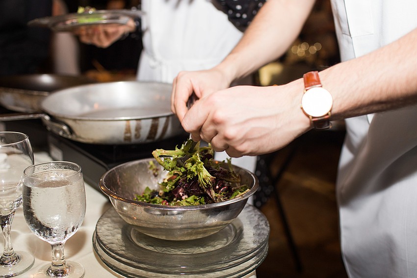 Daniel Palmizio tosses the salad.