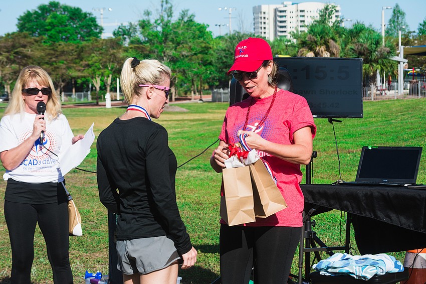 Tracee Murphy awards women's 5K first place winner, Christine Keller.
