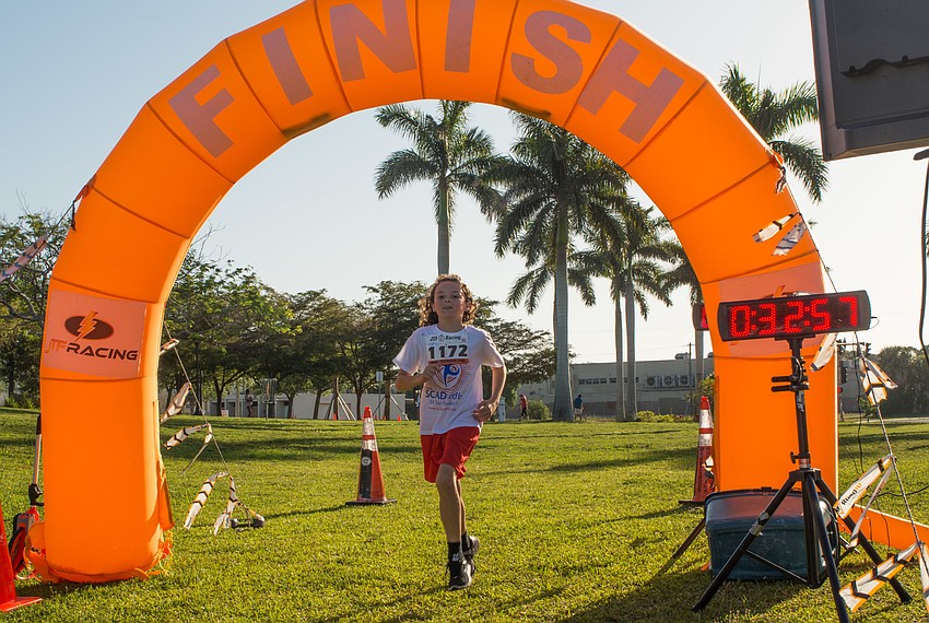 Aiden Sherlock, whose mom is a SCAD survivor, reaches the finish line.