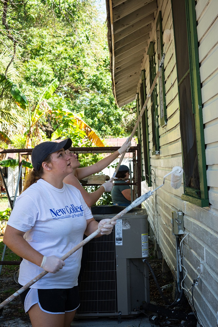 Angela McTigue and Rachel Pick paint a fresh new coat of paint on the Wright Bush home.
