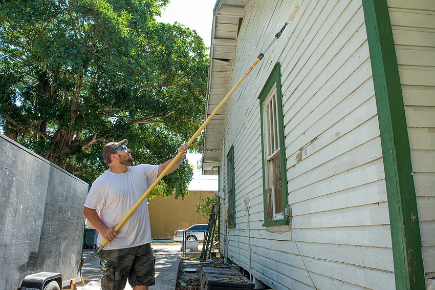 Garret Murto paint the back of the home.