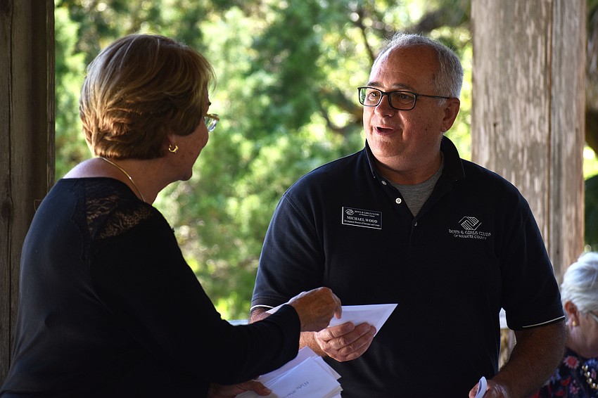 Grant Chairwoman Emmy Lou Gilbert presents Michael Wood of the Boys & Girls Club of Sarasota County with a check.