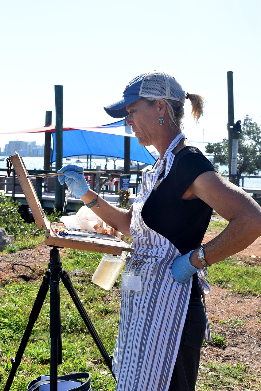 Sue Ginter works on her painting overlooking Sarasota Bay.