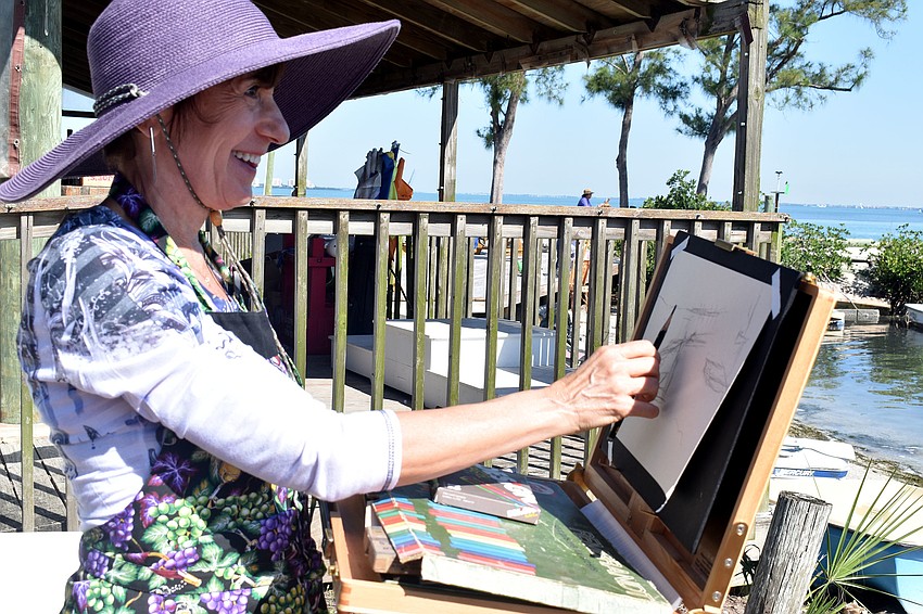 Phyllis Kessler sketches her drawing at the Sarasota Sailing Squadron.
