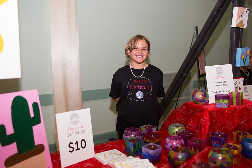 Sloan stands next to the candles for sale.