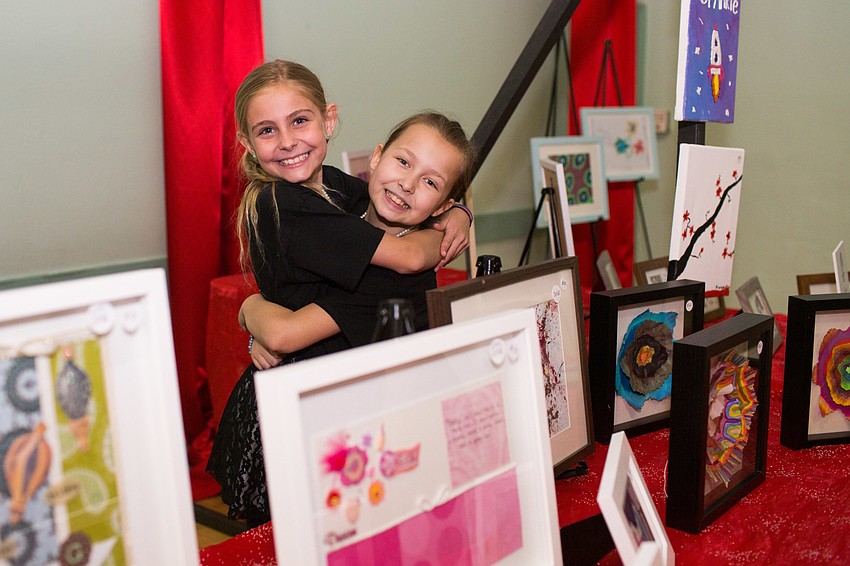 Evie and Jordan stand next to their artwork.