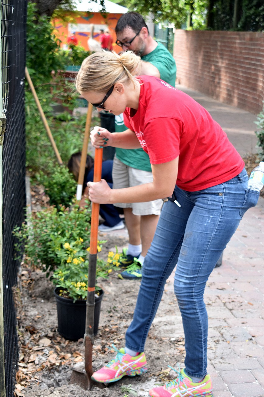 Jenn Poppen digs a hole for one of the 227 native plants.