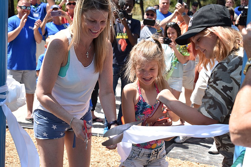 Erin Ditmars and her daughters Skyla Sousa and Saradi Bontrager cut the ribbon on the new playground.