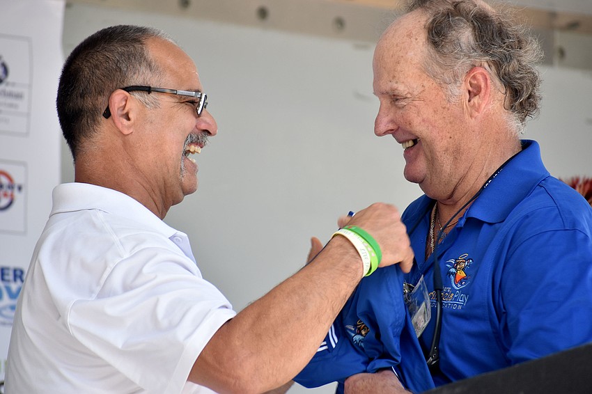Carlos Soto, father of Victoria Soto, who died in the Sandy Hook Elementary School shooting saving her students, presents a jacket to Rob Ditmas, father to Christopher and Jarrod Ditmars.