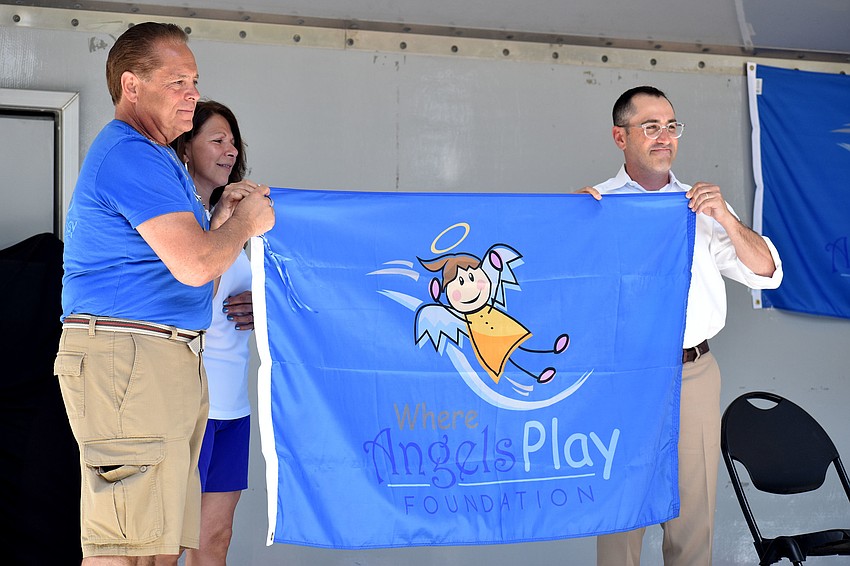 Sarasota commissioner Paul Caragiulo holds a flag representing Where Angels Play. The flag will remain in Sarasota.