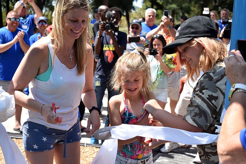Erin Ditmars and her daughters Skyla Sousa and Saradi Bontrager cut the ribbon on the new playground.