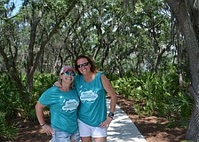 Jamie Rusnak of the Parrish YMCA and Stacey McKee of the Lakewood Ranch YMCA enjoy a walk on a trail that winds through the woods.