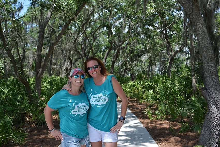 Jamie Rusnak of the Parrish YMCA and Stacey McKee of the Lakewood Ranch YMCA enjoy a walk on a trail that winds through the woods.