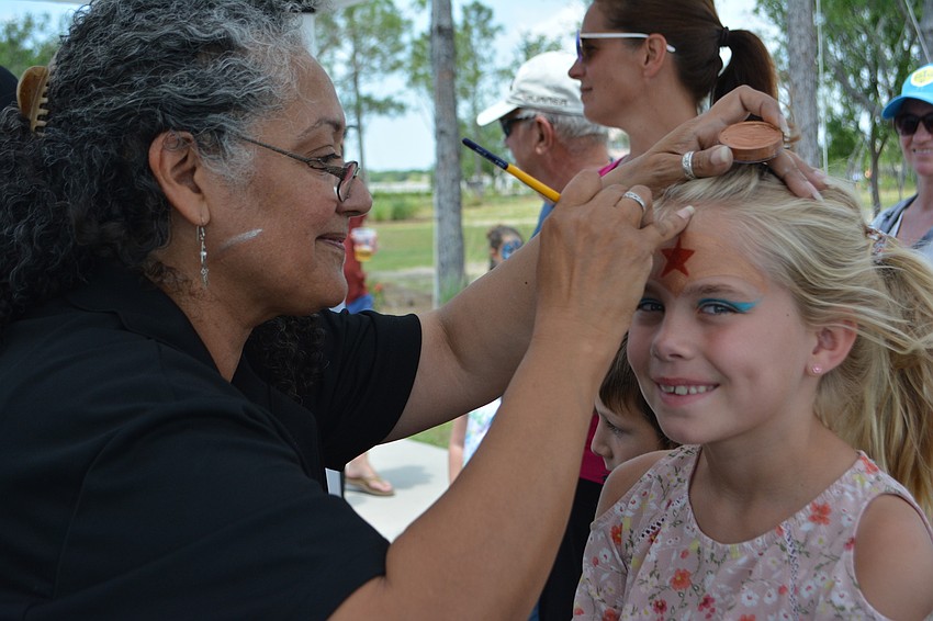 After her brother had a Spiderman face painting, Isabella Lawton, 7, was next up for artist Millie Duket.