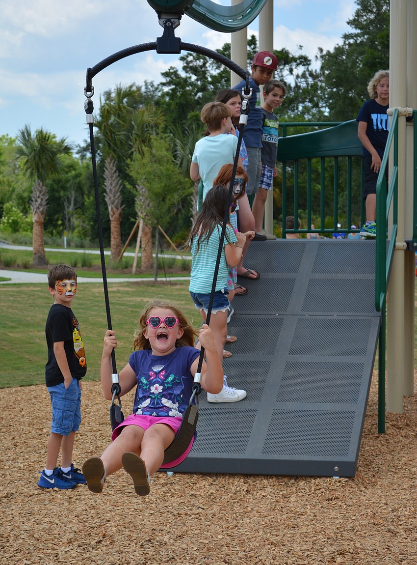 Lakewood Ranch's Katie Kuhlmann, 7, makes the most of her ride on the park's Gravity Rail.