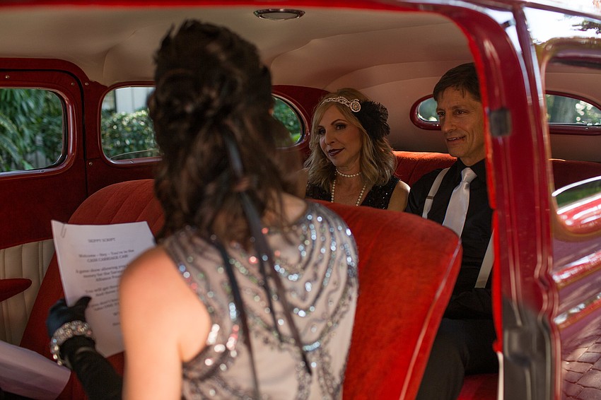 Co-Chairwoman Erin Lilly reads the cash cab questions to Hosts Bonnie and Skip Silverman