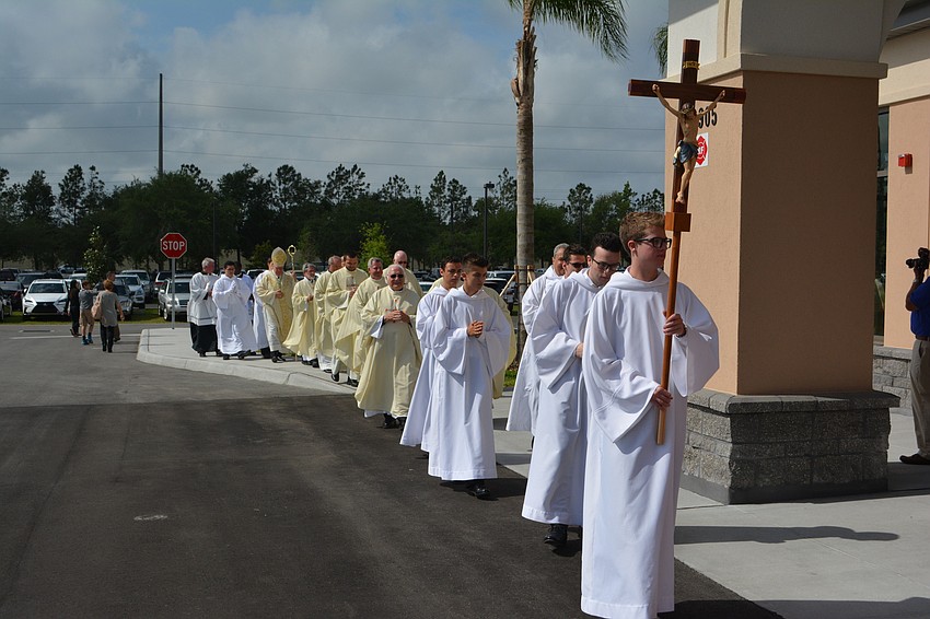 Church clergy approach the new Our Lady of the Angels church building.