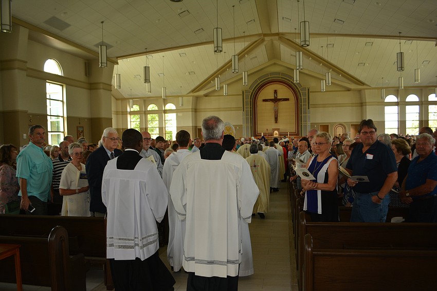 Parish clergy enter the sanctuary for its first mass.