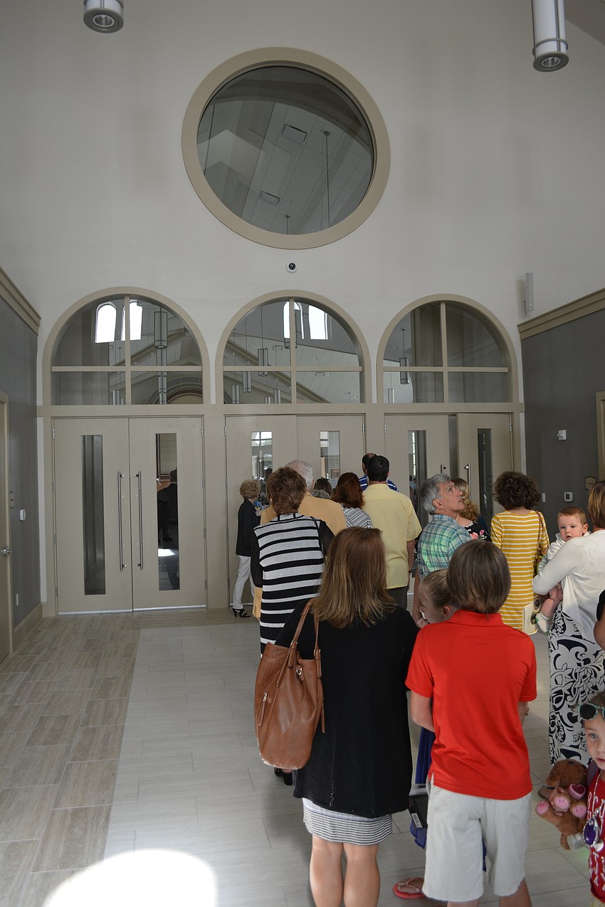 Parishioners wait in line, hoping to get into the first mass at the new building. It was at capacity 30 minutes before the service.