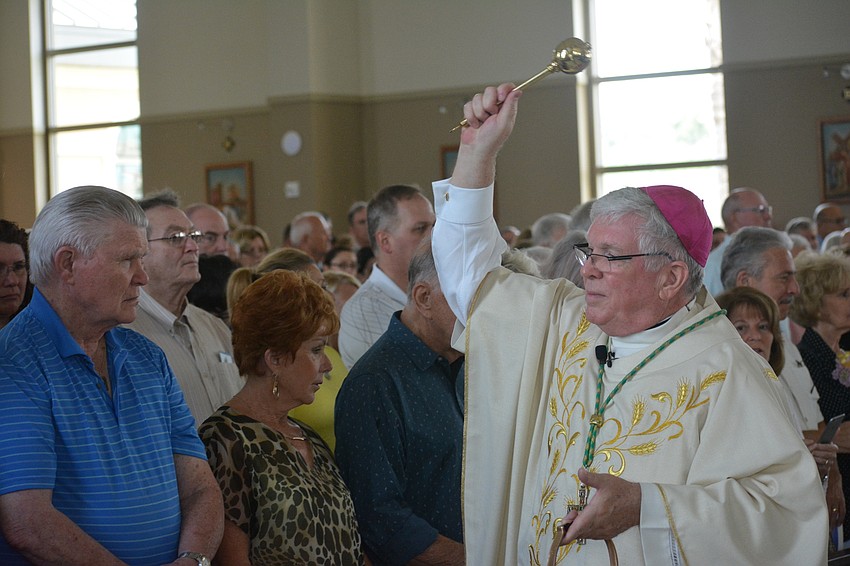 Rev. Frank Dewane, the bishop of the Diocese of Venice, blesses the parishioners with holy water.