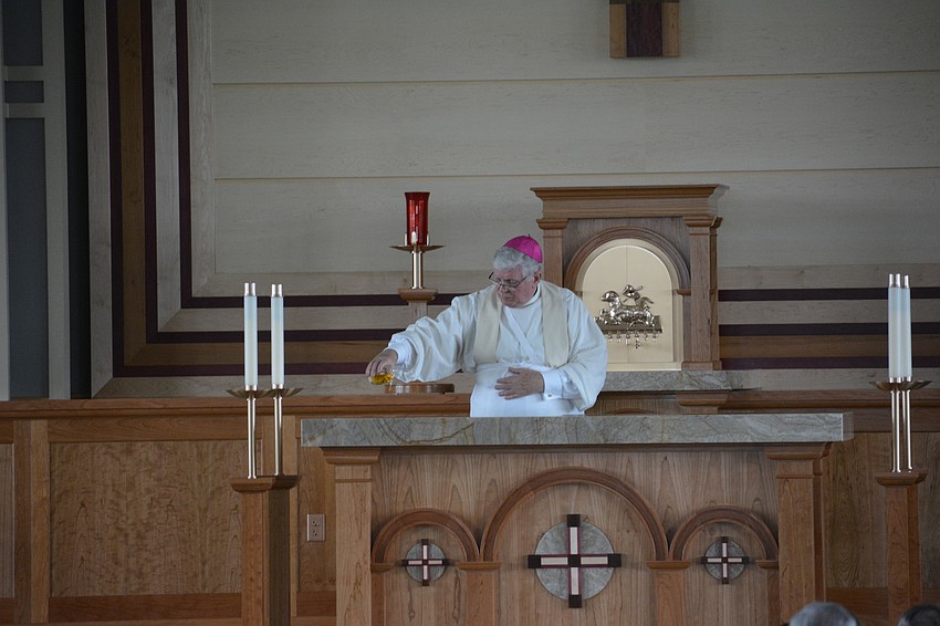 Rev. Frank Dewane, the bishop of the Diocese of Venice, anoints the alter with Sacred Chrism Oil.