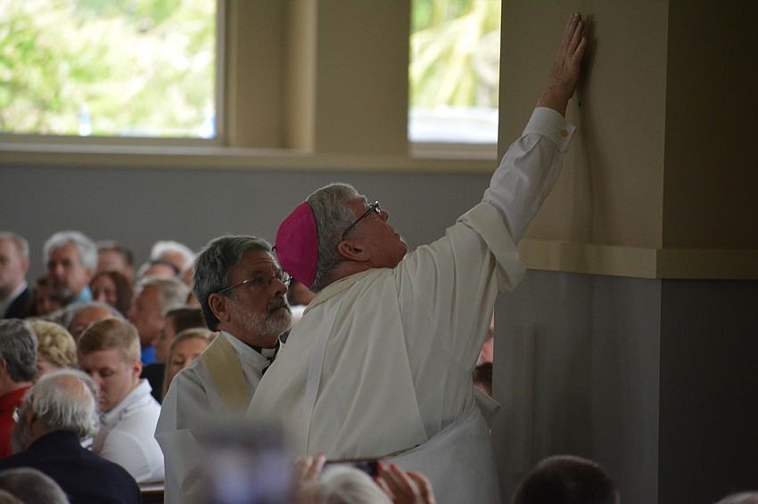 Rev. Frank Dewane, the bishop of the Diocese of Venice, anoints the walls of the church with Sacred Chrism Oil.