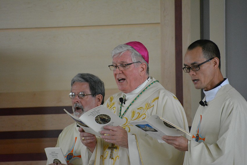 Rev. Michael Scheip, Rev. Frank Dewane, the bishop of the Diocese of Venice, and Rev. John Nghia Hoang sing a hymn during the service.