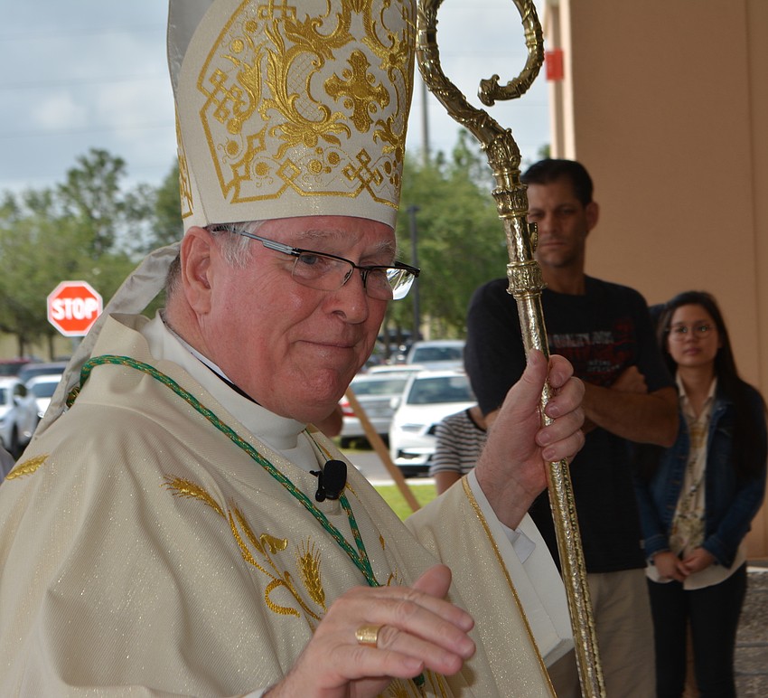 Rev. Frank Dewane, the bishop of the Diocese of Venice, greets parishioners as he enters the church after the dedication.
