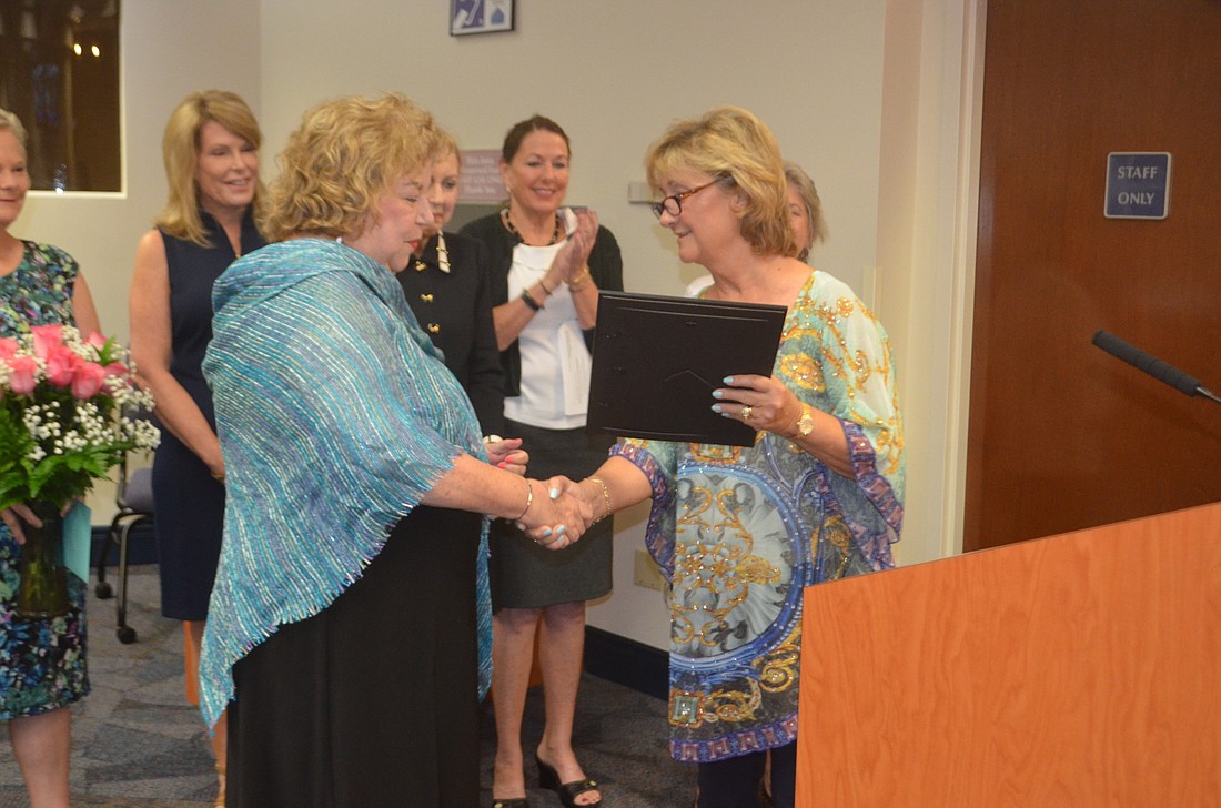 Peg McKinley accepts the County Commissioner&#39;s award from Vanessa Baugh during the meeting on April 24, 2018, now known as Palm Aire Women&#39;s Club day.