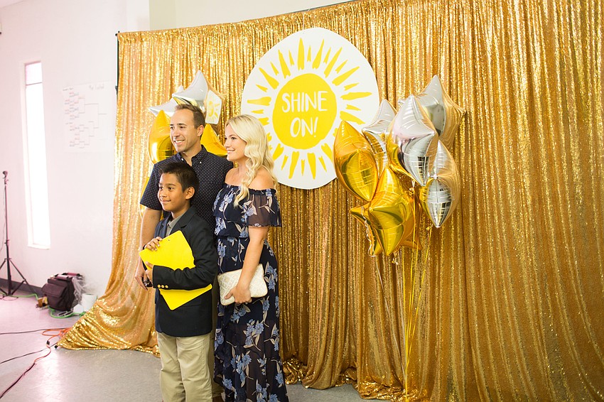 Evan and Michelle Brown take a photo with Visible Men Academy student Daniel.