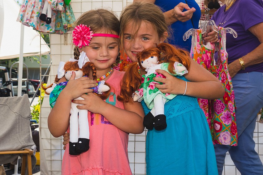 Megan and Mollie Baird enjoy their dolls they found at Siesta Fiesta.