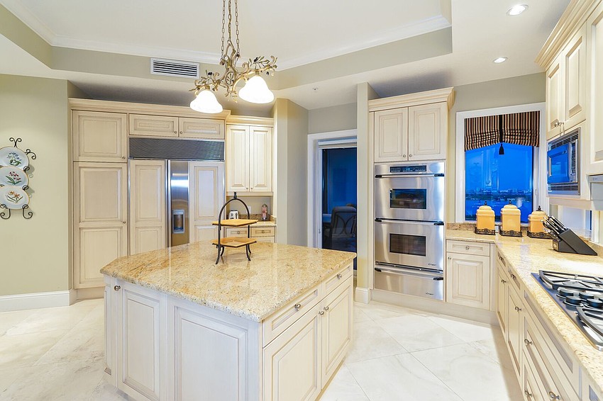 The kitchen features granite countertops, Sub-Zero refrigerator, double built-in Dacor ovens with warming drawer, gas cooktop, island, breakfast bar and planning desk.