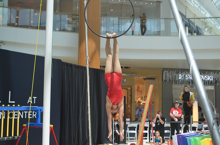 Emma Clarke, a seventh-grader from Sarasota, hangs from a hoop after her performance comes to a close.