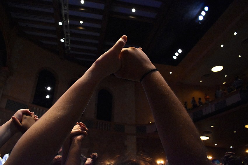 Audience members join hands in celebration at the end of the show.