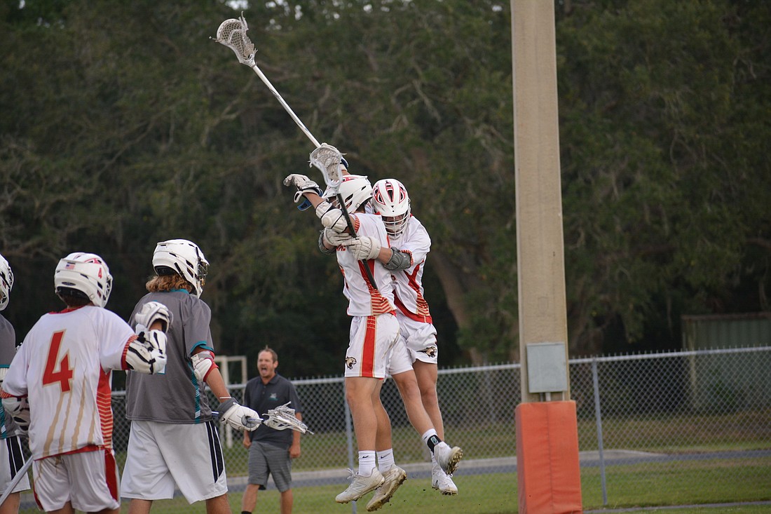 Ryan Katchen and Caleb Ward jump and hug after Katchen scored for Cardinal Mooney against Gulf Coast.