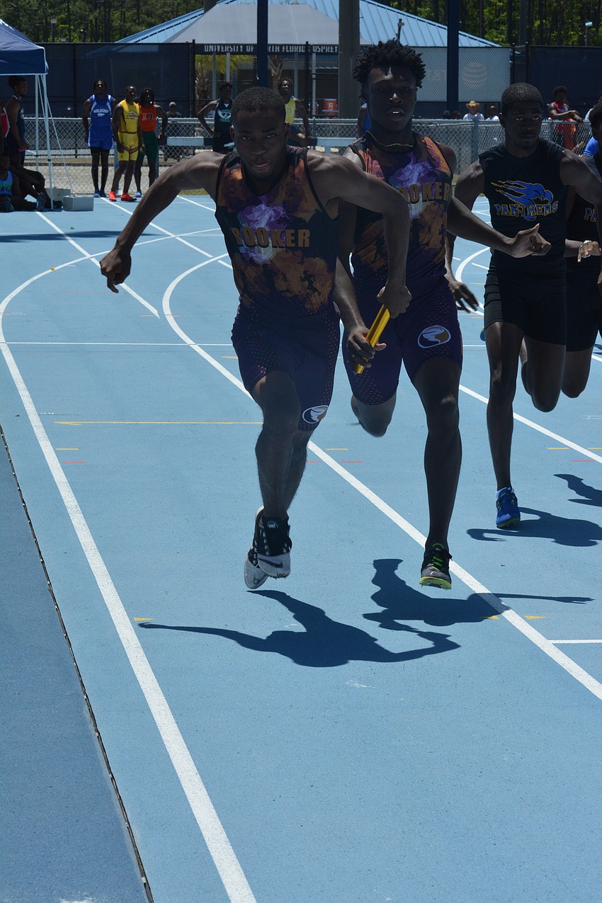 Booker High junior Joshua Ogden gets the baton from senior Anthony Thomas during the 2A boys 4x100-meter relay. Booker finished 21st overall.