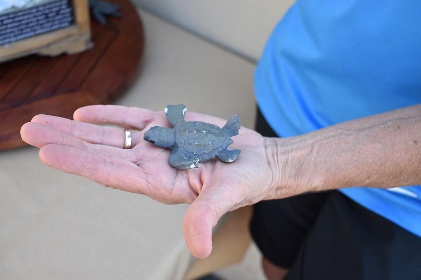 Volunteer Charlene Donnelly says it took a mix of four paint colors to get a color that was this close to the actual hue of baby sea turtles.