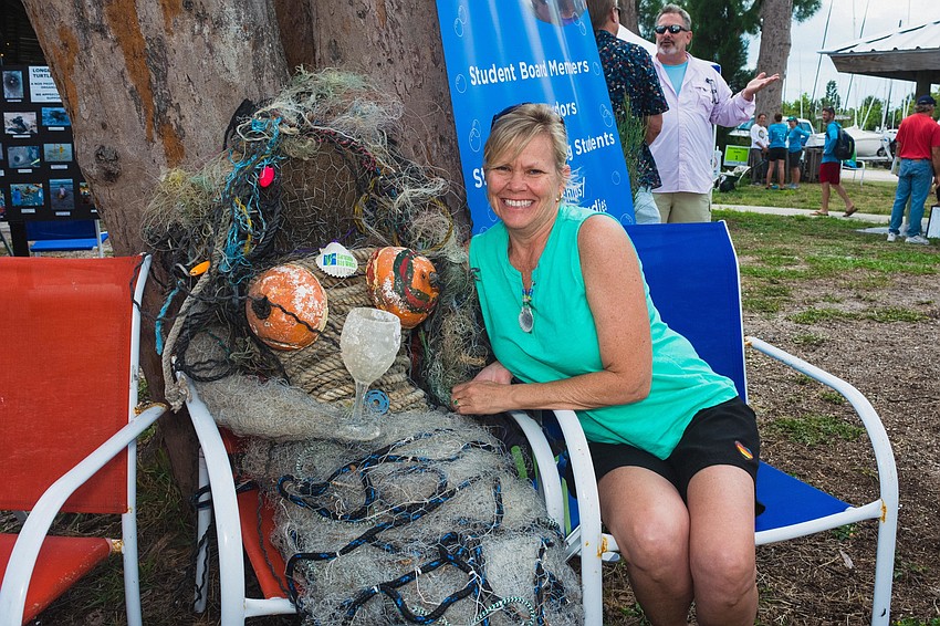 A volunteer poses with a mermaid made out of plastics pollution.