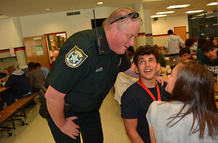 School Resource Officer Dep. Carl McClellan chats with Angel Perez (behind) and Christian Mark (front) during their lunch. Photo by Pam Eubanks.