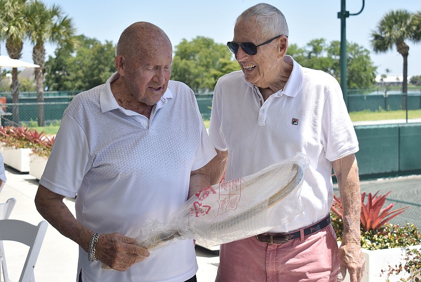 Bob Coyne presents Robert Ruff with a golden racket.