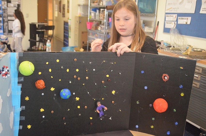 Samantha Berry, a fourth-grader, demonstrates the best way to position the claymation doll to get the best shot.