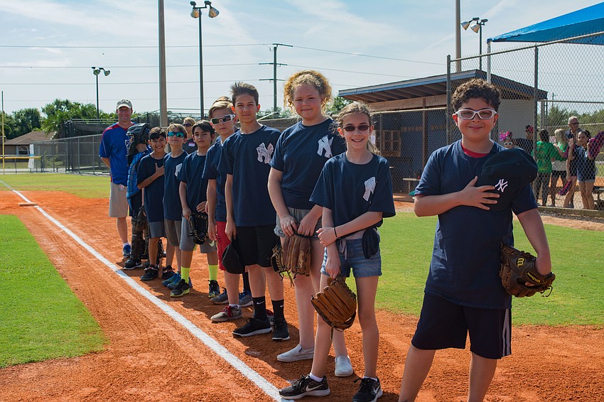 Students representing the New York Yankees prepare for the national anthem.