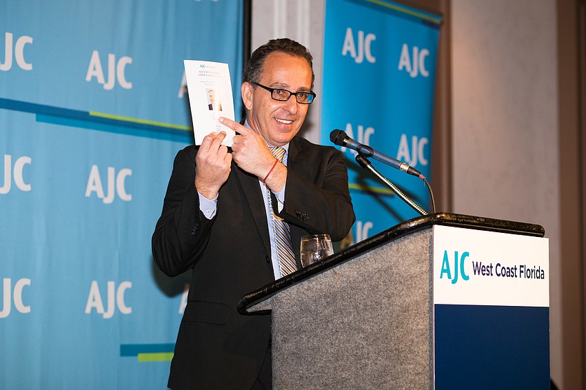 Speaker Juan Dircie jokes about filling in for the original speaker.