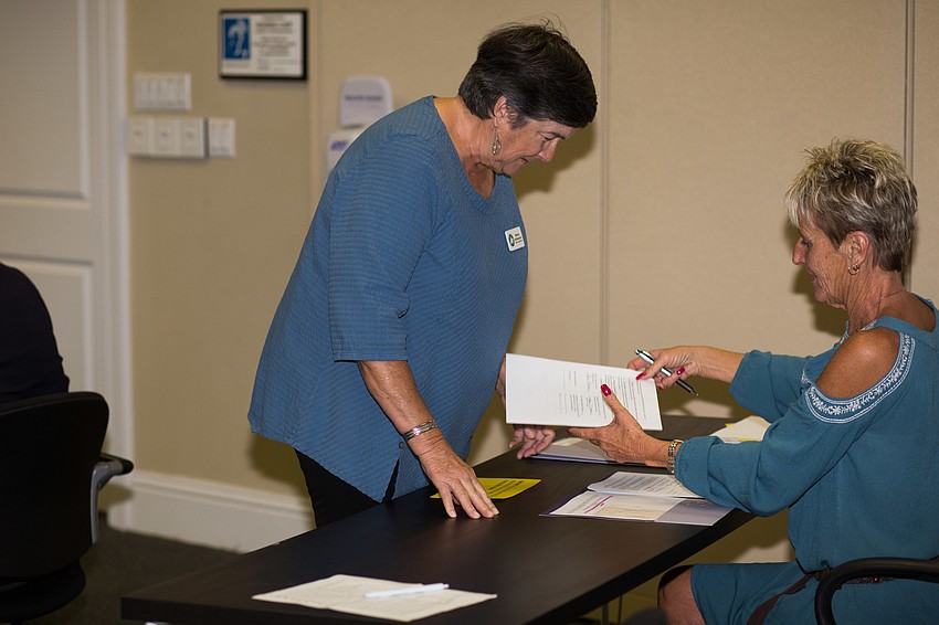 SMART representative Melissa Spillenkothen gets her paperwork from Co-Event Coordinator Jan Crudele.