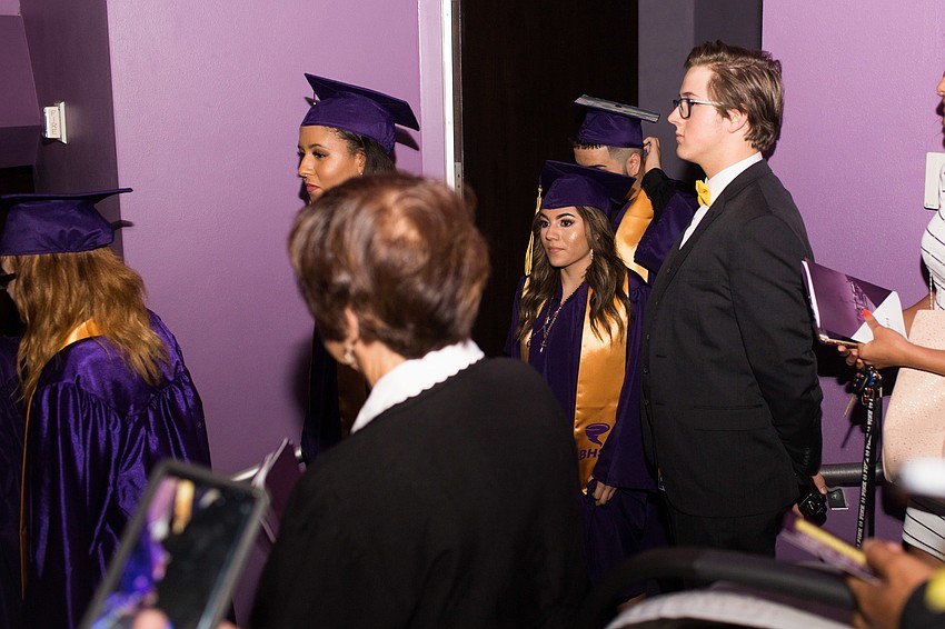The graduates entered the auditorium and made their way down the stairs.